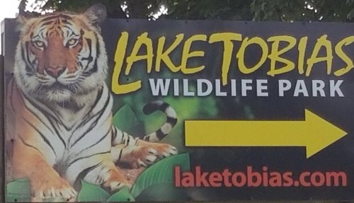 Sign for Lake Tobias Wildlife Park featuring a tiger and an arrow pointing to the right.