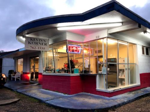 A brightly lit diner named "Kevin's Korner" with an open sign, featuring a retro architectural design.