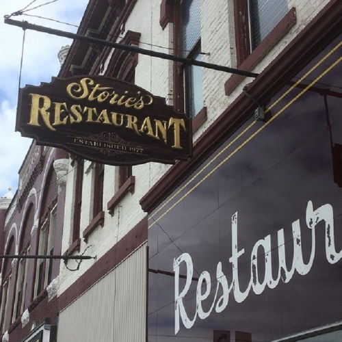 Sign for Storie's Restaurant, established in 1977, with a vintage design on a brick building.