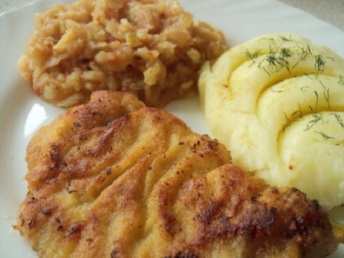 A plate featuring golden fried fish, creamy mashed potatoes, and a side of apple sauce.