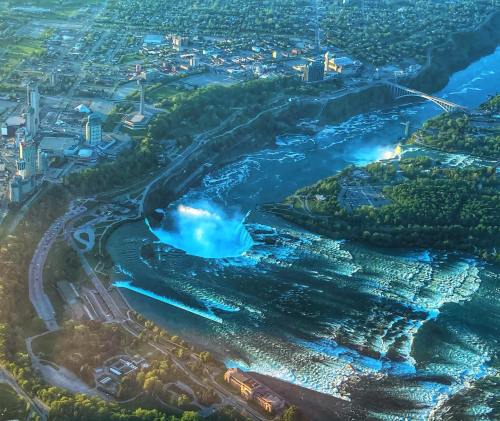 Aerial view of Niagara Falls, showcasing the cascading water and surrounding cityscape in the background.