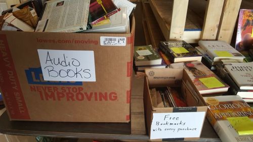 A cardboard box labeled "Audio Books" next to another box offering "Free Bookmarks with every purchase."