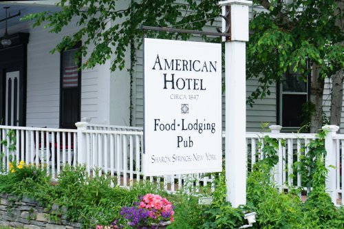 Sign for the American Hotel, established in 1847, offering food, lodging, and a pub in Sharon Springs, New York.