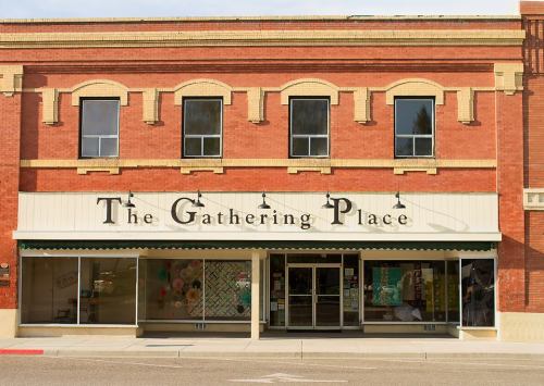 A brick building with large windows and a sign reading "The Gathering Place" above the entrance.