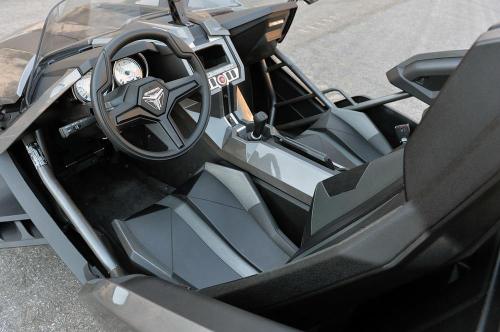 Interior view of a sleek, modern vehicle showcasing a minimalist dashboard and sporty seats.