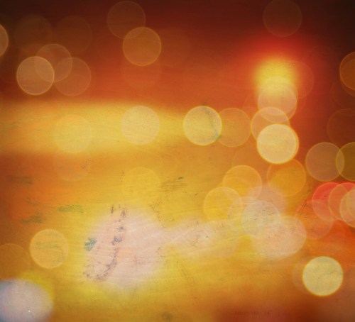 Abstract image featuring warm orange and yellow tones with soft, glowing bokeh lights creating a dreamy effect.