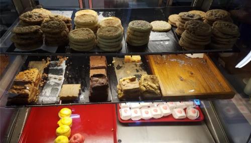 A display case filled with various cookies and desserts, including bars and colorful pastries.