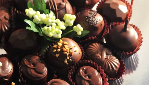 An assortment of elegant chocolate truffles with decorative flowers, arranged in a decorative display.