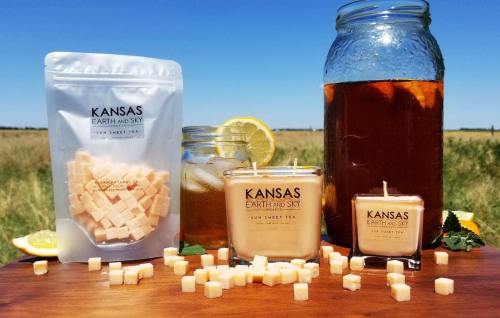 A sunny outdoor scene featuring sweet tea, candles, and wax melts with a Kansas Earth and Sky theme.