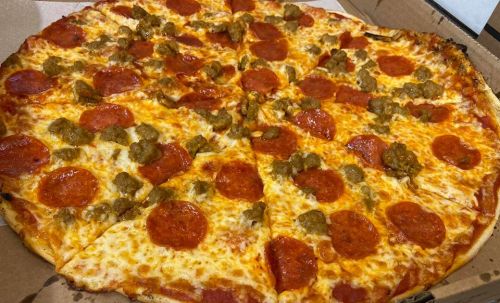 A large pizza topped with pepperoni and sausage, sliced into equal pieces, in a pizza box.