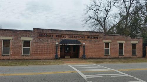 Exterior of the Georgia Rural Telephone Museum, featuring a brick facade and a covered entrance.