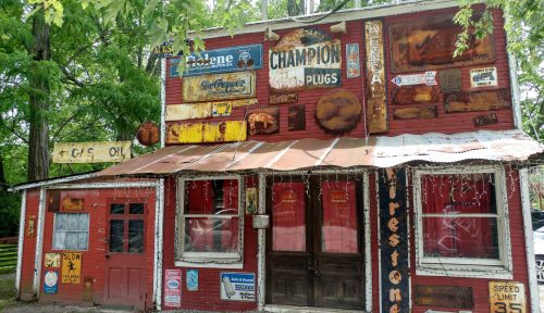 A vintage building adorned with various old signs and advertisements, featuring a rustic facade and colorful details.