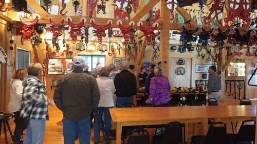 A group of people gathers inside a rustic room adorned with various vintage items and decorations.