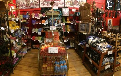 A colorful shop interior filled with various incense, candles, and decorative items on shelves and displays.