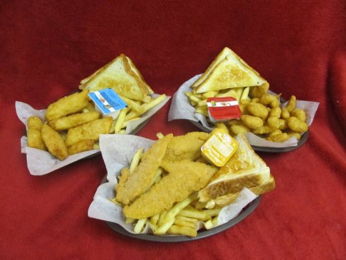Three plates of fried fish, golden fries, and toast, with dipping sauces, set against a red background.