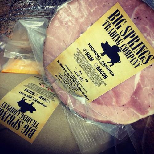 Label of Big Springs Trading Company featuring hickory smoked ham and bacon, with packaging details visible.