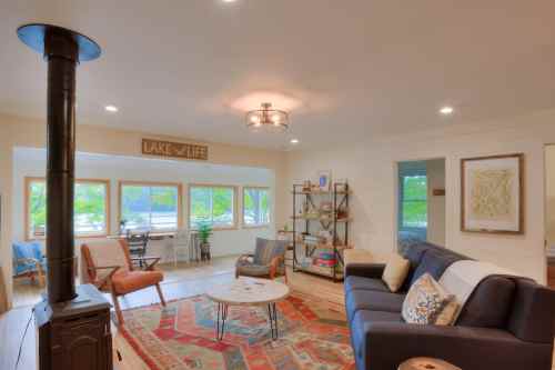 Cozy living room with a lake view, featuring a sofa, coffee table, bookshelf, and warm lighting.