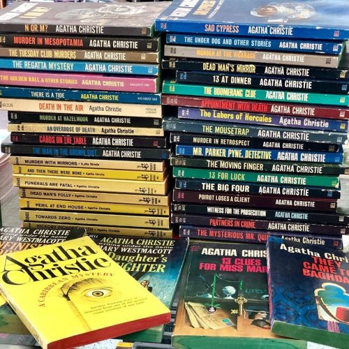 A stack of Agatha Christie books, featuring various titles and editions, showcasing her iconic mystery novels.