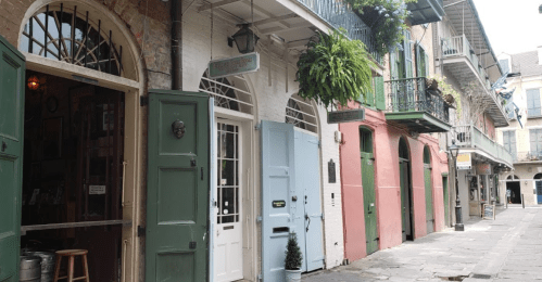Charming street view with colorful buildings, balconies, and greenery in a historic area.