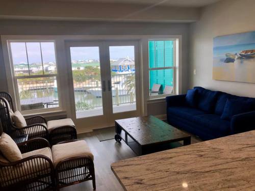 Cozy living room with a blue couch, wooden coffee table, and large windows showcasing a waterfront view.