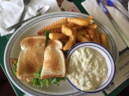 A plate with a toasted sandwich, crinkle-cut fries, and a bowl of creamy soup with vegetables.