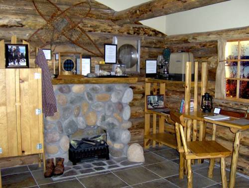 Cozy log cabin interior featuring a stone fireplace, wooden furniture, and rustic decor.