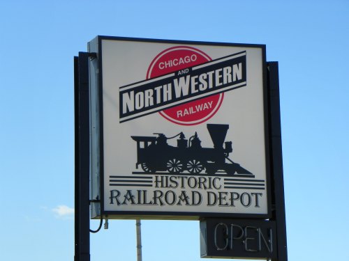 Sign for the Chicago and North Western Railway, featuring a silhouette of a steam locomotive and "Historic Railroad Depot."