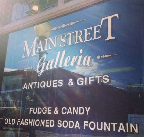 Sign for "Main Street Galleria" featuring antiques, gifts, fudge, candy, and an old-fashioned soda fountain.
