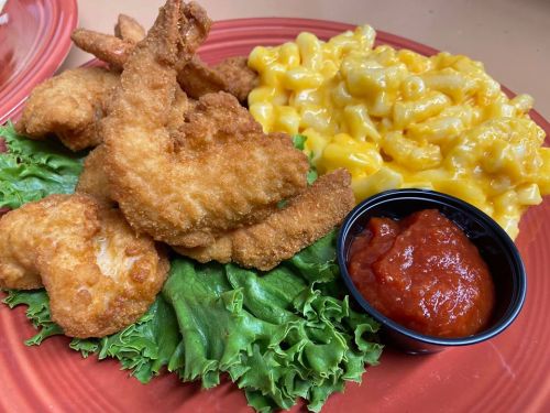 A plate featuring crispy fried fish, macaroni and cheese, lettuce, and a side of marinara sauce.