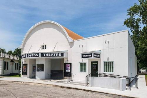 Exterior of Dyess Theatre, featuring a white facade, marquee, and welcoming entrance, set in a quiet street.