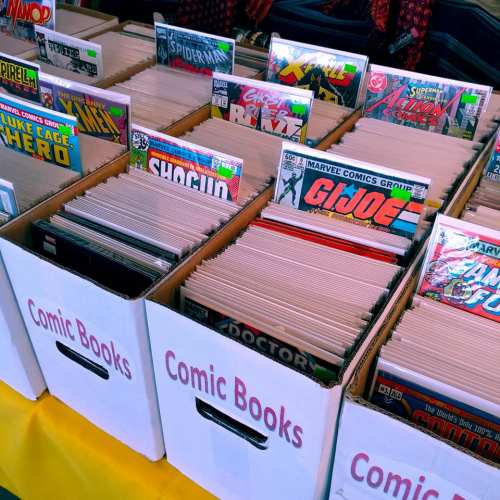 Boxes filled with comic books, featuring colorful covers and titles like "Spider-Man" and "G.I. Joe."