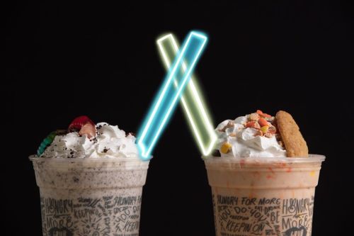 Two milkshakes topped with whipped cream and colorful toppings, with glowing neon X shapes in the background.