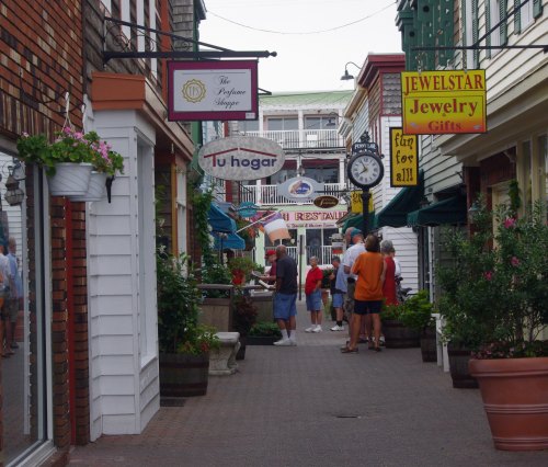 A charming street lined with shops and colorful signs, with people browsing and enjoying the atmosphere.