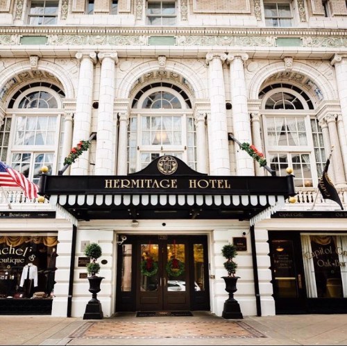 Exterior of the Hermitage Hotel featuring elegant architecture, festive decorations, and welcoming entrance.