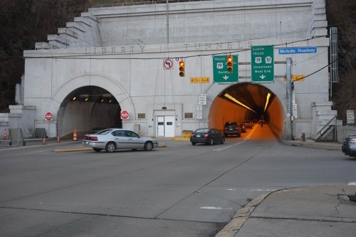 Entrance to the Liberty Tunnels, with traffic lights and vehicles approaching the tunnel openings.