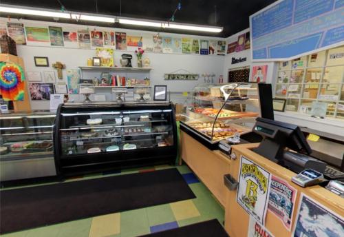 A cozy bakery interior featuring display cases of pastries, colorful decor, and a welcoming atmosphere.
