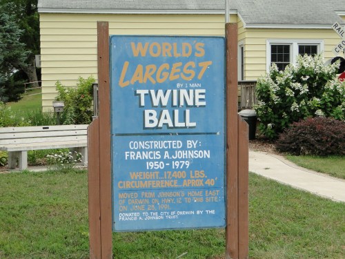 Sign for the World's Largest Twine Ball, constructed by Francis A. Johnson, detailing its weight and history.