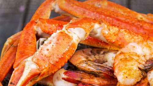 A close-up of cooked shrimp and crab legs, showcasing their vibrant orange color and texture.