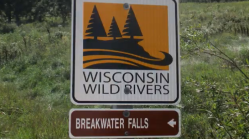 Sign for Wisconsin Wild Rivers with a graphic of trees and water, pointing towards Breakwater Falls.