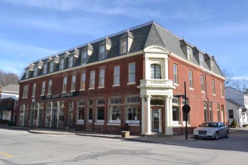 Historic brick building with a decorative roof, featuring large windows and a corner entrance, set against a clear blue sky.