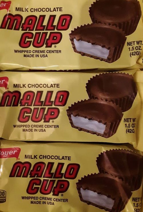 Three Mallo Cups wrapped in yellow packaging, showcasing milk chocolate and whipped cream center.