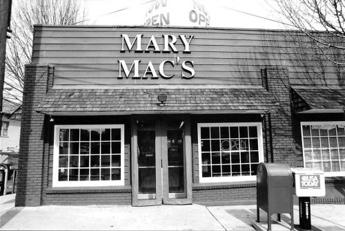 Black and white image of Mary Mac's restaurant exterior with large windows and an "Open" sign.