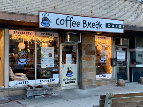 A cozy café storefront with a sign reading "Coffee Break Café," featuring windows displaying coffee and bagel offerings.