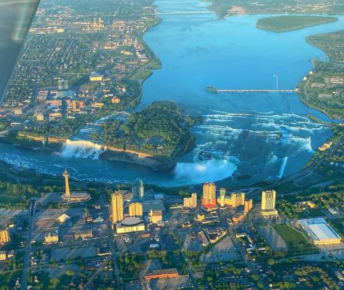 Aerial view of Niagara Falls, showcasing the waterfalls, river, and surrounding cityscape.