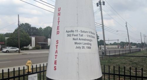 A tall model of the Apollo 11 Saturn V rocket, with details about its height and the moon landing date.