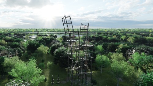 Aerial view of a lush green landscape featuring tall wooden structures and a river under a bright sky.
