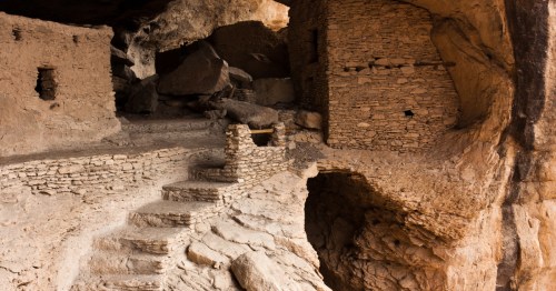 Ancient stone masonry rooms and steps built into a large natural rock alcove at Gila Cliff Dwellings.
