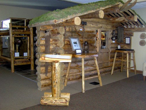 A rustic log cabin interior with a moss-covered roof and wooden furniture, showcasing a cozy, natural aesthetic.