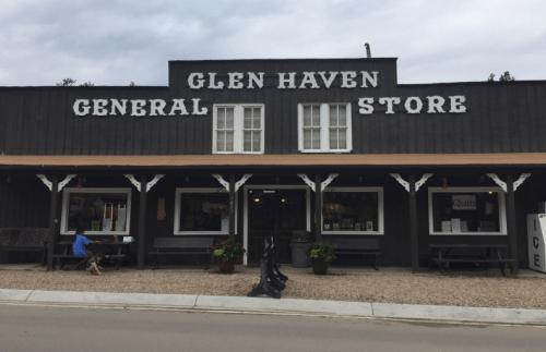 Front view of the Glen Haven General Store, featuring wooden architecture and outdoor seating.
