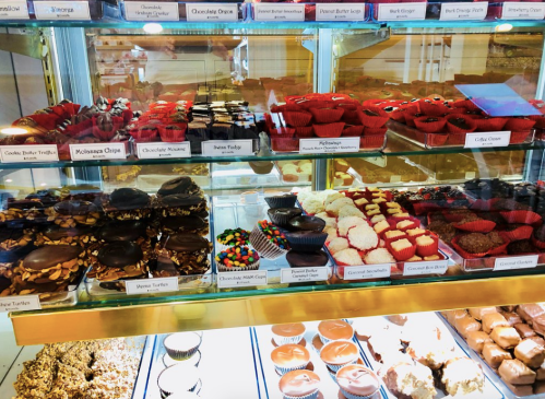 A display case filled with various chocolates and confections, including turtles, truffles, and colorful candies.